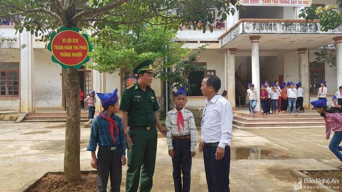 Bố nuôi Bộ đội Biên phòng Đồn Keng Đu trao đổi tình hình học tập của 2 con với thầy giáo ở trường. Ảnh: Thành Chung