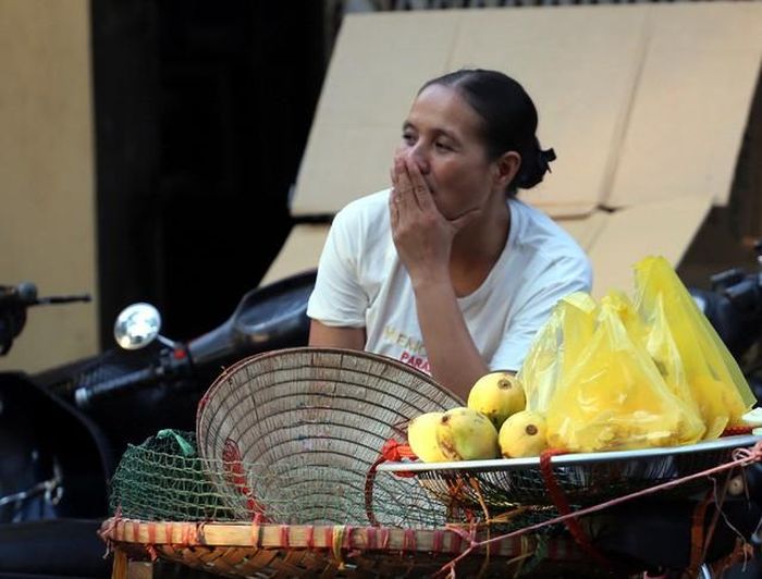 Người phụ nữ bán hàng rong đang "hong" những trái xoài dưới nắng thu.