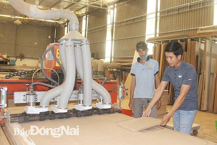 Anh Trần Ngọc Anh hướng dẫn công nhân vận hành máy CNC 4 đầu được sản xuất theo ý tưởng của anh. Ảnh:V.Gia