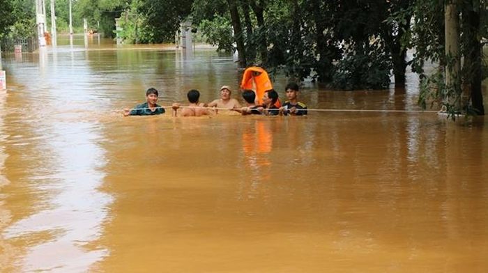  Trong dòng nước lũ chảy xiết, lực lượng cứu hộ phải rất vất vả bám vào từng gốc cây, cột điện để đưa xuồng cứu hộ tiếp cận các ngôi nhà có người bị kẹt 