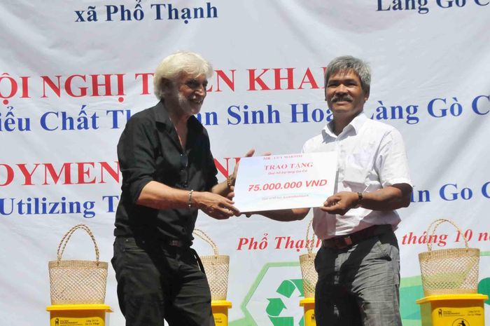 Ông Guy Martini giao tặng 75 triệu đồng cho làng Gò Cỏ. Ảnh: NGUYỄN TRANG