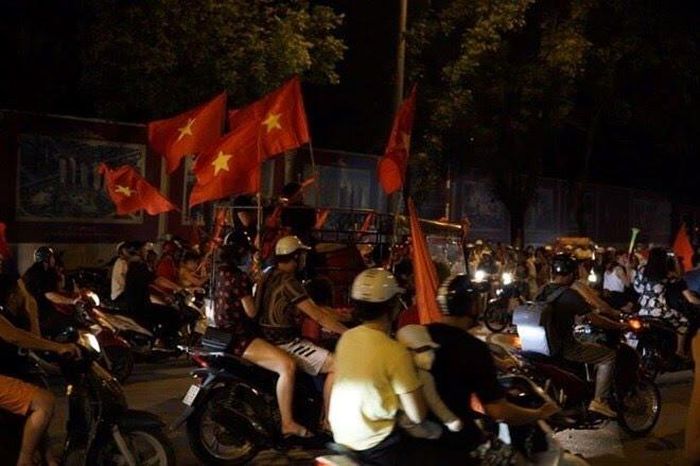 Dòng người hâm mộ mang theo cờ đỏ sao vàng ùa ra đường ăn mừng chiến thắng.