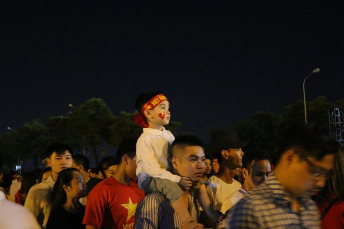 Những đứa trẻ yên tâm ngồi trên vai người thân đi ăn mừng.