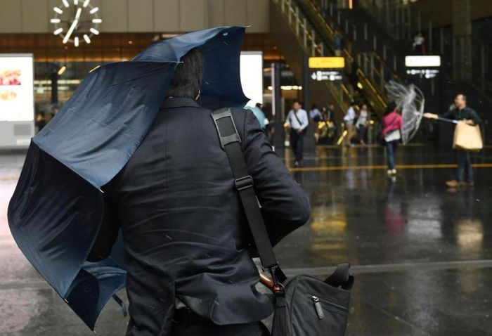 Người dân đi dưới mưa gần ga Osaka. (Ảnh: Reuters/Annegret Hilse)