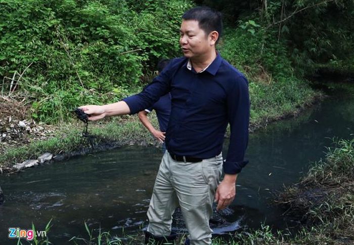 Sau hơn 1 tuần phát hiện việc đổ trộm dầu thải, nước của suối đầu nguồn nơi cung cấp nước sạch sông Đà vẫn một màu đen kịt. Ảnh: Hồng Quang.