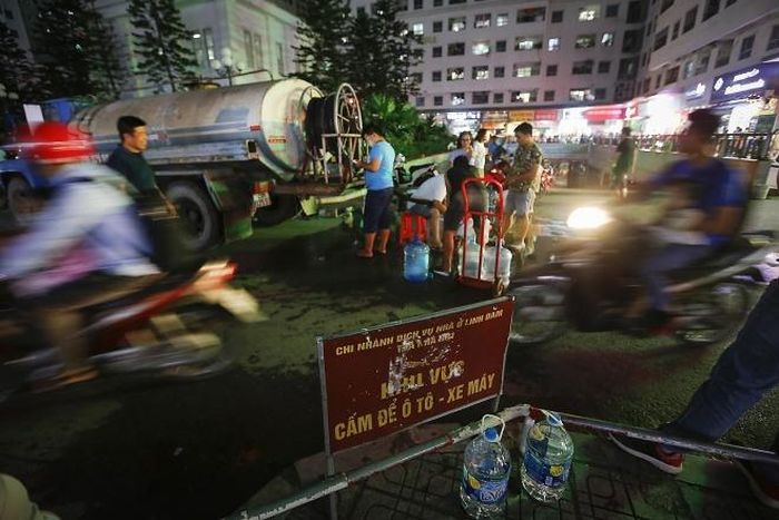  Đến tối muộn, vẫn còn nhiều người dân sinh sống ở KĐT Linh Đàm xếp hàng lấy nước sinh hoạt từ xe téc nước dịch vụ