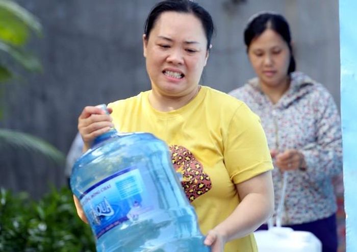 Người dân lấy nước sạch miễn phí tại nhà máy nước Hạ Đình sáng ngày 16/10.
