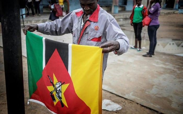 Biểu tượng Xô viết tại châu Phi gồm súng trường Kalashnikov được in trên cờ của Mozambique. Ảnh: AFP
