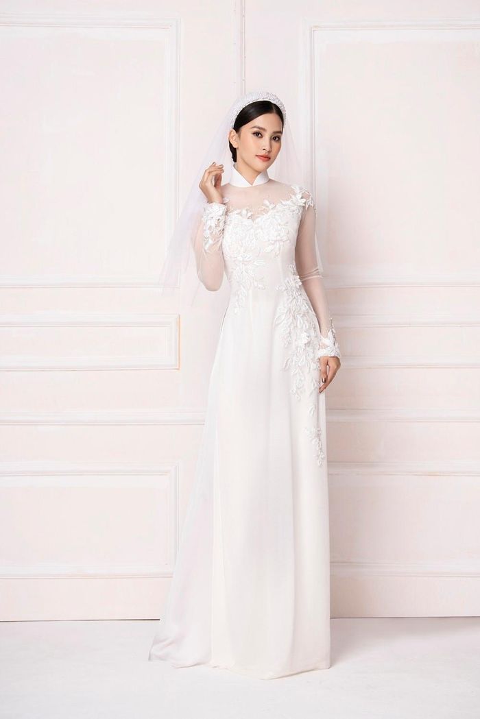 Thiết kế áo dài khoét cổ sâu kết hợp vải xuyên thấu tạo nên vẻ gợi cảm cho Tiểu Vy. Thiết kế này còn được đính kết hoa 3D ở phần ngực áo, ống tay.