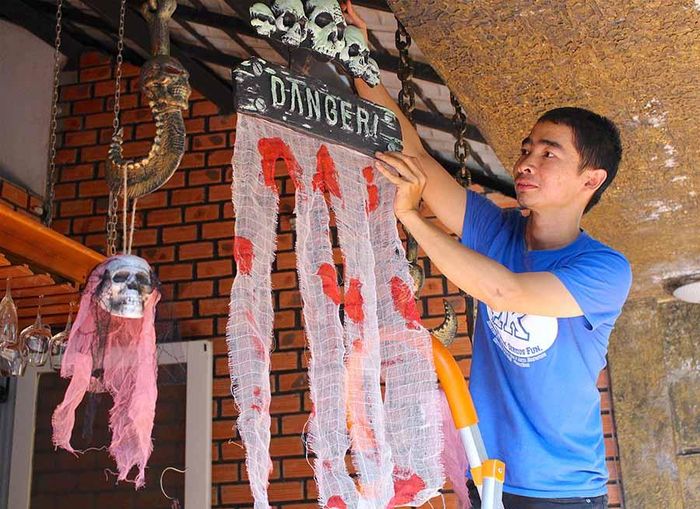 Anh Phan Toàn (chủ quán Cuội Acoustic) trang trí quán chuẩn bị cho đêm hội Halloween Party. Ảnh: Mộc Trà