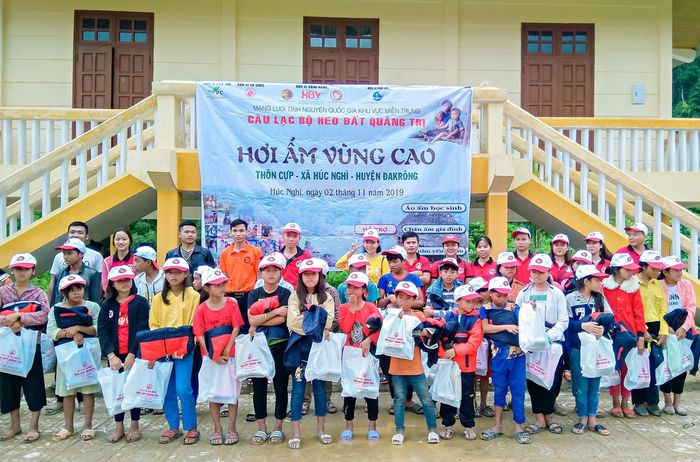 Các tình nguyện viên trao quà cho học sinh thôn Cựp