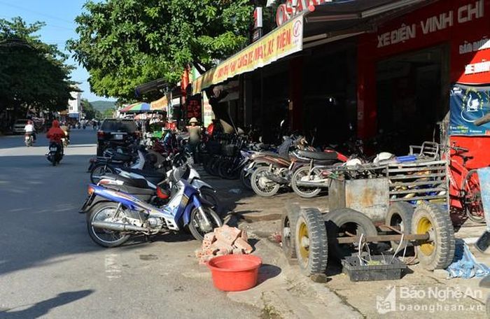 Ông Nguyễn Hữu Vân – Chủ tịch UBND thị trấn Đô Lương cho biết: Do yếu tố lịch sử để lại, hầu hết hệ thống đường nội thị hiện nay không có vỉa hè, hoặc có thì cũng chỉ rộng khoảng 1,5m, cá biệt có những chỗ chỉ hơn 50cm. Ngoài ra, bám mặt đường những tuyến đường nội thị chủ yếu là các hộ kinh doanh, nên tình trạng bày bán hàng hóa lấn chiếm vỉa hè còn xảy ra. Để giải quyết tình trạng lấn chiếm vỉa hè, đảm bảo an ninh, trật tự và ATGT, UBND thị trấn đã lập đội quy tắc đô thị, mỗi tuần đi kiểm tra 2 - 3 buổi, thu hàng nghìn biển quảng cáo. Tuy nhiên, khi lực lượng chức năng rời đi, tình trạng tái lấn chiếm lại xảy ra. Ảnh: Thành Cường.
