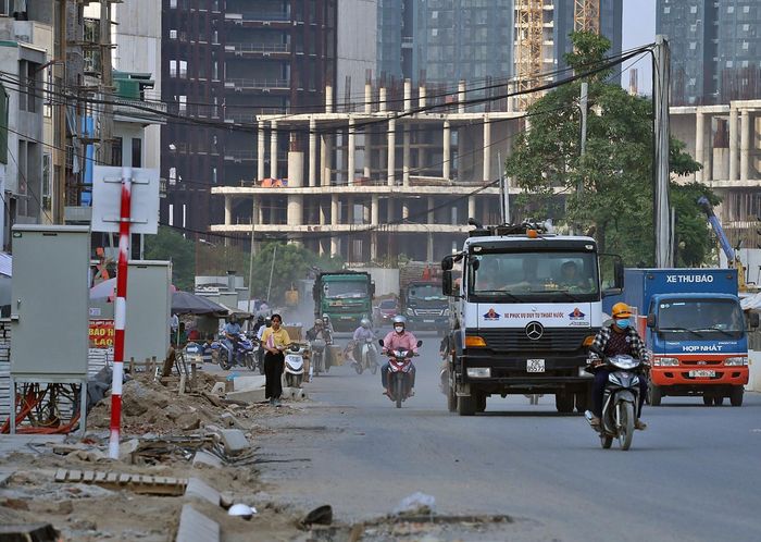  Đường Phạm Văn Đồng được thông xe phần dưới nhưng nhiều đoạn vẫn đang ngổn ngang vật liệu xây dựng, đổ xuống cả lòng đường.