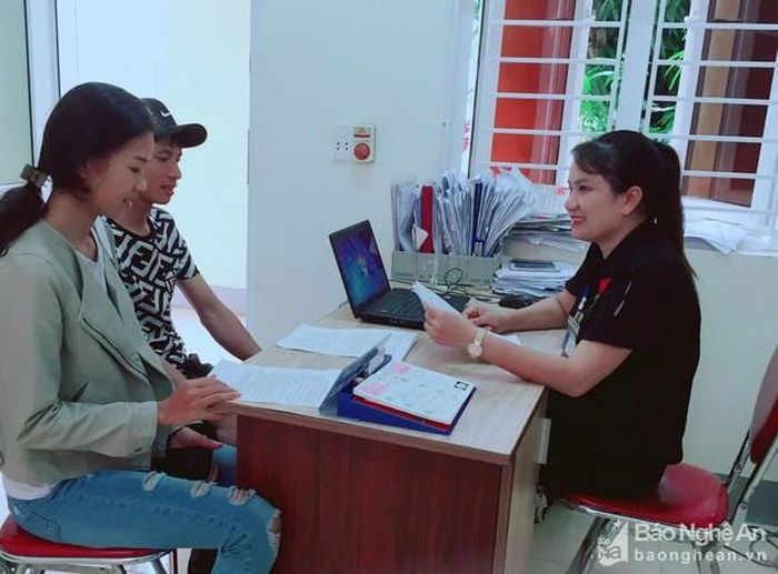 Công chức xã Hưng Lĩnh (huyện Hưng Nguyên) tư vấn định hướng thị trường xuất khẩu lao động cho người dân. Ảnh: Mai Hoa