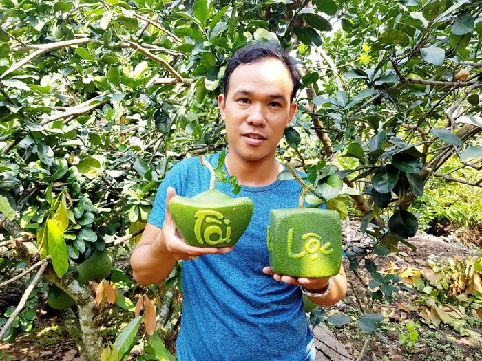 Anh Tâm cầm bưởi tạo hình Tài - Lộc