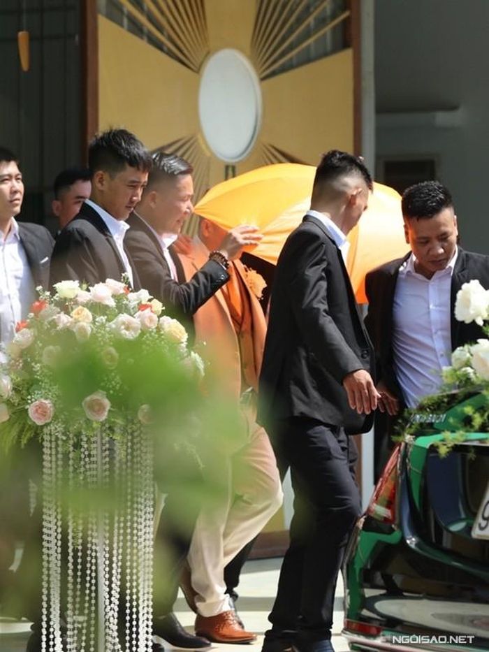 Sau phần làm lễ ở nhà thờ, doanh nhân Phan Lĩnh (vest trắng) được hộ tống ra xe để trở về nhà riêng.