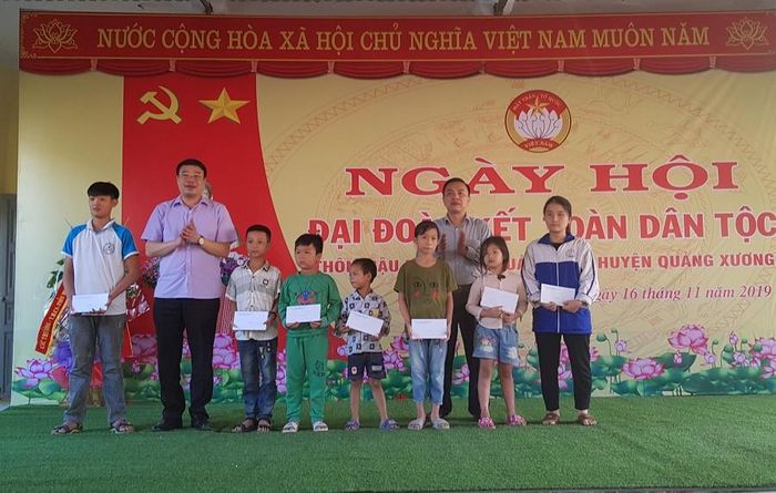 Lãnh đạo huyện Quảng Xương tặng quà cho các học sinh nghèo thôn Mậu Đông. 