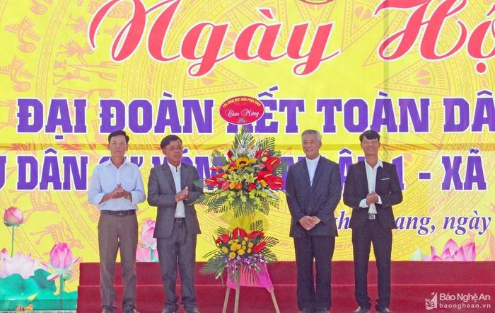 Đức cha Anphongsô Nguyễn Hữu Long - Giám mục Giáo phận Vinh trao tặng hoa chúc mừng Ngày hội Đại đoàn kết toàn dân xóm Tân Lập 1. Ảnh: Thanh Quỳnh
