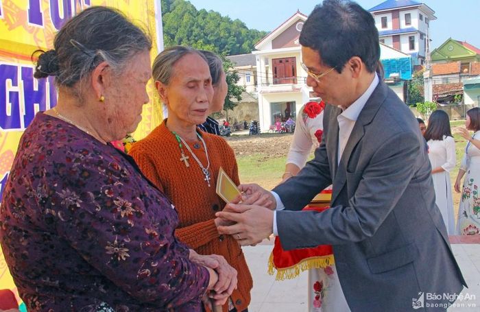 Đồng chí Phó Bí thư Thường trực Tỉnh ủy Nguyễn Xuân Sơn trao quà cho các hộ có hoàn cảnh khó khăn của xóm Tân Lập 1 trong ngày hội. Ảnh: Thanh Quỳnh
