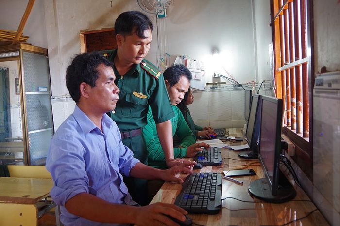  Thiếu tá Ngô Minh Đức hướng dẫn cán bộ, nhân dân thôn Thiện Cư, xã Thiện Hưng sử dụng máy tính để soạn thảo các văn bản.