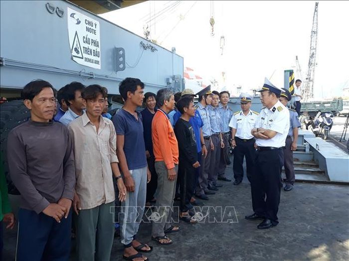 Lãnh đạo Vùng 4 Hải quân thăm hỏi sức khỏe của các ngư dân tàu cá QNg 96549 TS và đoàn kiểm ngư hỗ trợ lai dắt tàu cá vào bờ an toàn. Ảnh: Phan Sáu/TTXVN