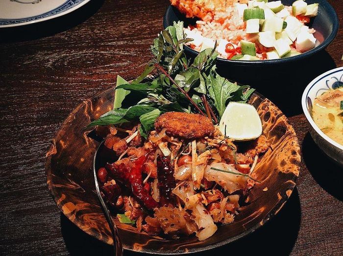 Nếu bạn yêu thích sự biến tấu hài hòa của những hương vị mới, Yum Neam Kao Tod là một lựa chọn hấp dẫn. Món ăn bao gồm thịt lợn lên men, trộn với các loại gia vị như bột ớt khô, và được phủ cơm chiên giòn bên trên. Điều đặc biệt ở món ăn này là những miếng sứa nhỏ, được nêm nếm đậm đà. Yum Neam Kao Tod có giá 220 baht (khoảng 170.000 đồng). Ảnh: Anemone_kate. 