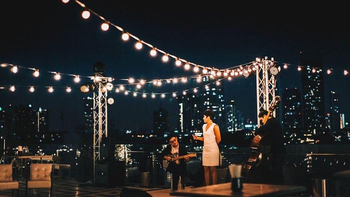 Thứ 7 và chủ nhật hàng tuần, bạn sẽ có cơ hội nghe nhạc acoustic. Nhiều thực khách từng trải nghiệm tại đây hài lòng về vị trí, có thể nhìn toàn cảnh sông Chao Phraya. Các món ăn cũng được nhận xét có mức giá rẻ hơn so với các nhà hàng nằm ở tầng thượng khác. Tuy nhiên, cocktail được làm khá ngọt nên có thể không phù hợp khẩu vị một số người. Ảnh: TopKnotBangkok.