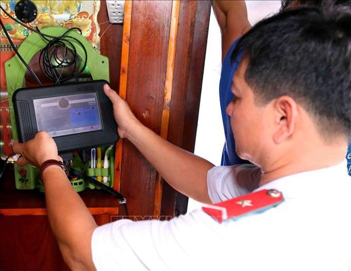 Thanh tra ngành hải sản kiểm tra thiết bị giám sát hành trình khai thác trên tàu cá tại cảng cá Tắc Cậu (Kiên Giang). Ảnh: Vũ Sinh/TTXVN