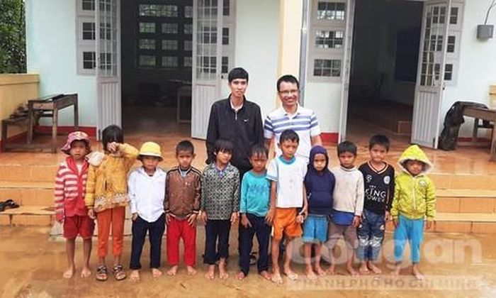 Thầy Tuyền (mặc áo khoác đen) và 11 em học sinh chụp hình chung với phóng viên