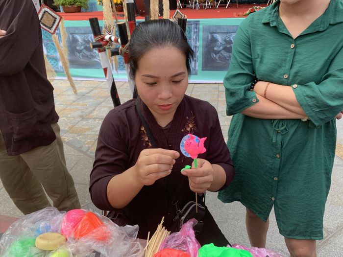 Nghệ nhân biểu diễn nặn tò he hình các chú lợn.