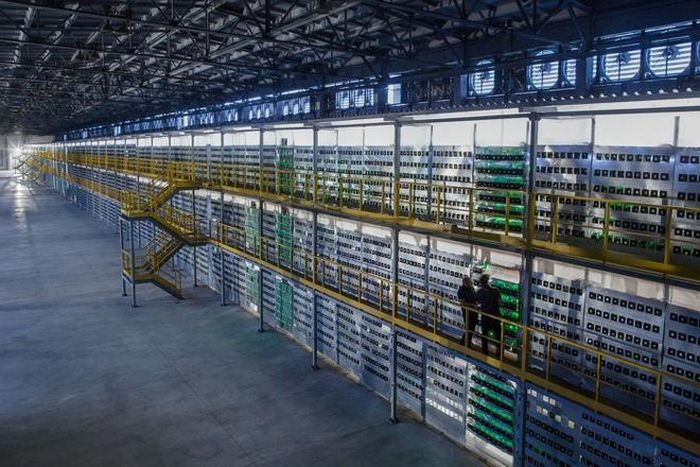 Các giá đỡ ba tầng của vi mạch tích hợp dành riêng cho ứng dụng (ASIC) và những bộ nguồn nằm trên tường của cơ sở khai thác 100 megawatt. Một loạt quạt công nghiệp lớn chạy dọc theo chiều dài tòa nhà, làm mát các máy móc khi chúng khai thác tiền điện tử.