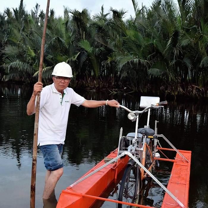 Ông Hà bên chiếc xe đạp chạy dưới nước do mình chế tạo.