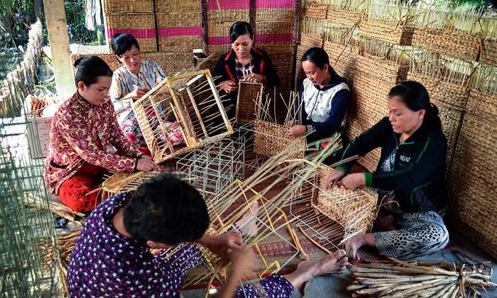 Người dân Ninh Quới thoát thoắt đan lục bình sau khi phơi khô thành những chiếc giỏ. (ĐỒ HIẾU LIÊM – BẠC LIÊU)