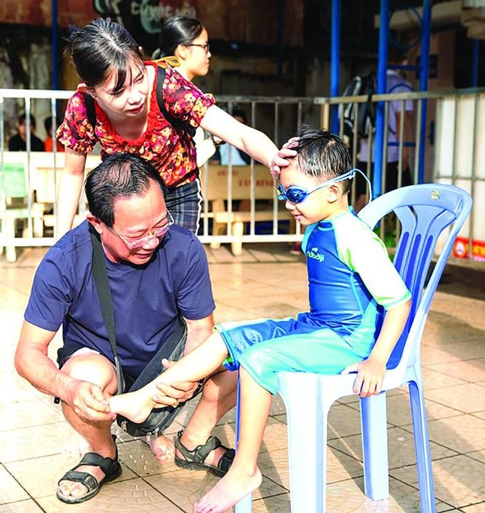 Phụ huynh hướng dẫn các em trước khi thi bơi