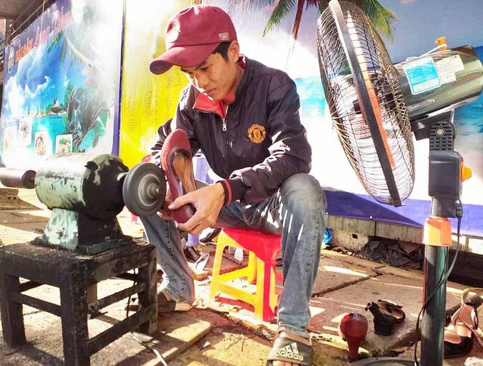 Anh Thắng đang tập trung mài đế giày bằng cao su. Ảnh: P.D
