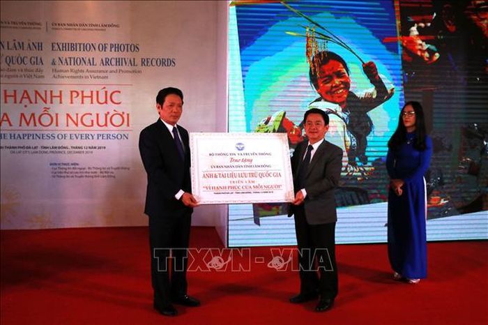 Thứ trưởng Bộ Thông tin và Truyền thông Hoàng Vĩnh Bảo (trái) trao tặng toàn bộ ảnh, tư liệu cho Phó Chủ tịch UBND tỉnh Lâm Đồng Phan Văn Đa.