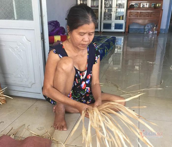 Chị Bảy so lá trước khi đan.