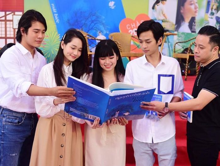  Đạo diễn bộ phim Mắt Biếc Victor Vũ và các diễn viên chính đóng trong bộ phim Trần Nghĩa, Trúc Anh, Trần Phong và Khánh Vân chiêm ngưỡng cuốn sách Mắt Biếc độc bản lớn nhất tại ngày hội. 