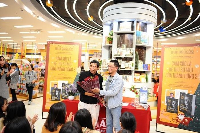 TS Lê Thẩm Dương nhận hoa từ đại diện nhà sách.