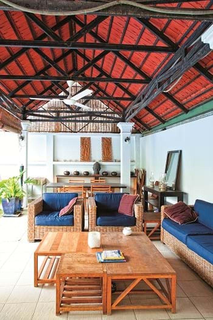 Hiên nhà với bộ sofa mây, ghế gỗ.