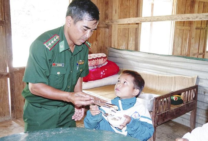 Cán bộ Đồn biên phòng A Vao chăm sóc các cháu có hoàn cảnh đặc biệt khó khăn được nhận nuôi tại đồn. Ảnh: T.L