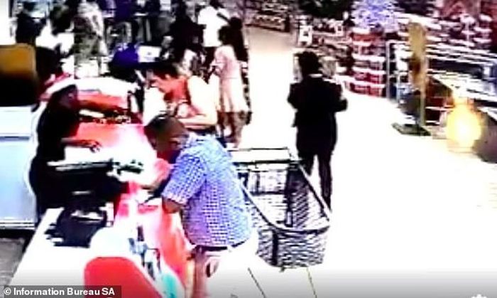  Bế bé trai ra khỏi xe đẩy chở hàng siêu thị, kẻ bắt cóc từ tốn bế bé ra ngoài.