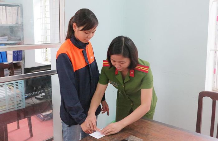 Công an huyện Tam Nông giúp người dân lăn tay làm thủ tục cấp giấy chứng minh nhân dân.