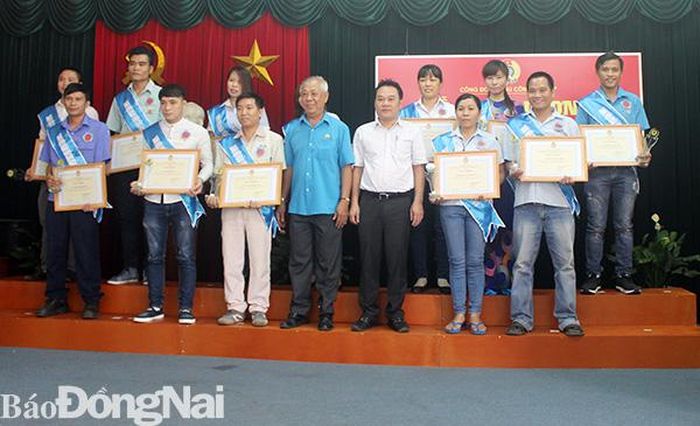 Chị Vũ Thị Kết (hàng sau, thứ ba từ phải qua) cùng đồng nghiệp nhận giấy khen đoàn viên Công đoàn tiêu biểu năm 2018 của Công đoàn khu công nghiệp Biên Hòa. Ảnh: T.Lâm