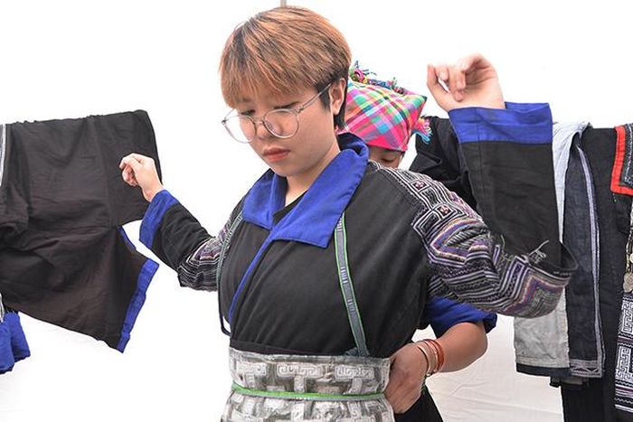 Một bạn trẻ tìm hiểu về trang phục thổ cẩm của phụ nữ Mông.