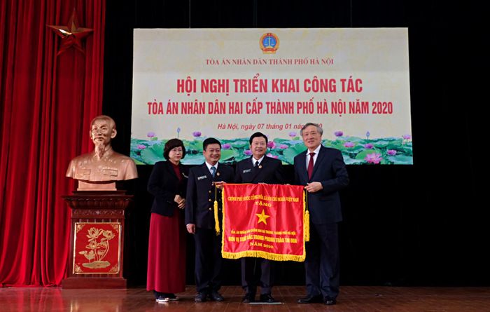 Đồng chí Chánh án TANDTC Nguyễn Hòa Bình trao cờ thi đua của Chính phủ cho tập thể TAND quận Hai Bà Trưng