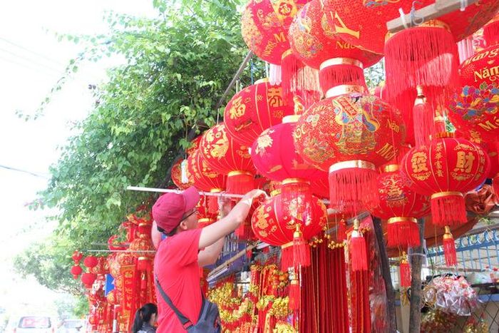 Người bán đèn lồng treo thêm đèn cho gian hàng rực rỡ