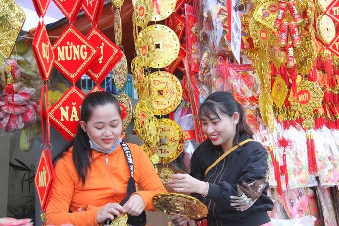 Người bán hàng treo thêm phụ kiện cho đồng tiền may mắn 