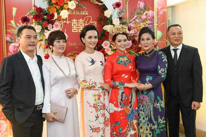 Trong khi cô dâu cực kỳ nổi bật thì mẹ và chị gái cô lại ăn mặc, trang điểm khá nền nã. Mẹ Quỳnh Anh diện trang phục áo dài tối màu in hình công phượng, dù là phu nhân nhưng bà không đeo quá nhiều trang sức trong đám hỏi của con gái.