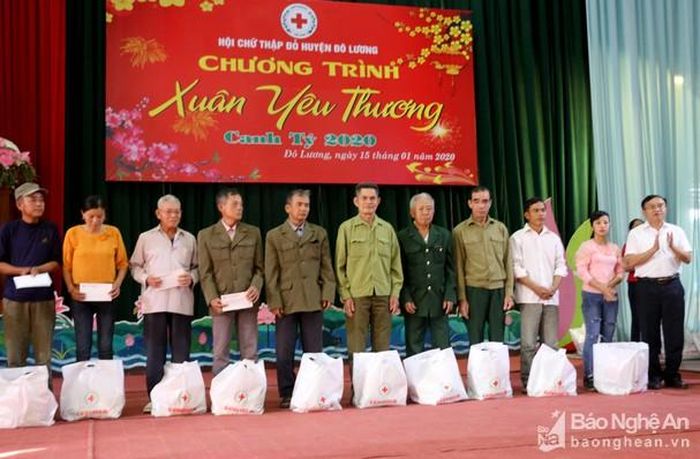 Các đồng chí lãnh đạo huyện trao quà của Hội Chữ thập đỏ cho những hộ nghèo, trẻ em mồ côi tật nguyền. Ảnh: Sỹ Bắc